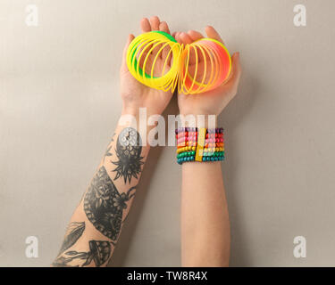 Woman holding rainbow slinky on grey background, top view Stock Photo