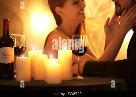 Burning candles and wine on table creating romantic atmosphere for loving couple Stock Photo