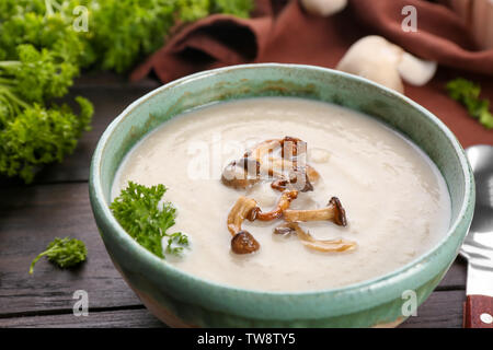 Bowl with delicious mushroom soup on wooden table Stock Photo