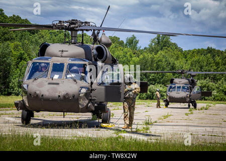 U.S. Army aviators with the 1st Assault Helicopter Battalion, 150th Aviation Regiment, New Jersey Army National Guard, prepare to take off in a UH-60L, front, and a UH-60M Black Hawk during an interagency coordination exercise at the Homeland Defense Technology Center, Picatinny Arsenal, N.J., June 14, 2019. The 150th Aviation Regiment trained with the 21st Weapons of Mass Destruction-Civil Support Team and the New Jersey Department of Corrections C.O.B.R.A. (Chemical, Ordnance, Biological, Radiological, Aid) unit. (New Jersey National Guard photo by Mark C. Olsen) Stock Photo