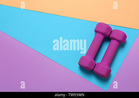 Dumbbells and blank space for exercise plan on color background. Flat lay composition Stock Photo