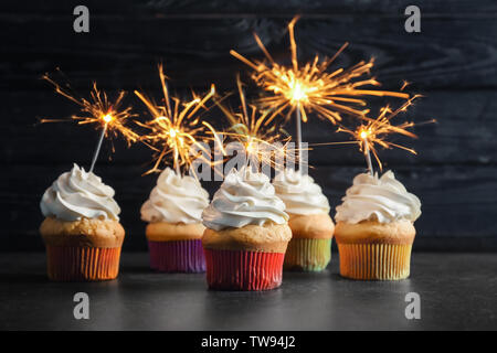 Birthday cupcakes with sparklers on table Stock Photo