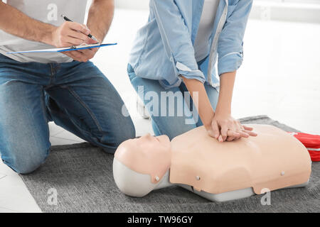 Woman practicing CPR on mannequin in first aid class, closeup Stock Photo