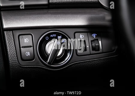Close-up on the headlight switch control buttons,  automatic adjust level dashboard. modern car interior: parts, buttons, knobs Stock Photo