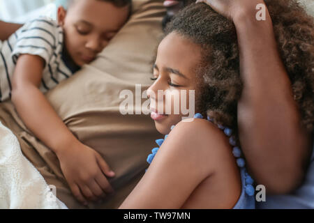 African American man sleeping with his children in bed. Family bedtime Stock Photo
