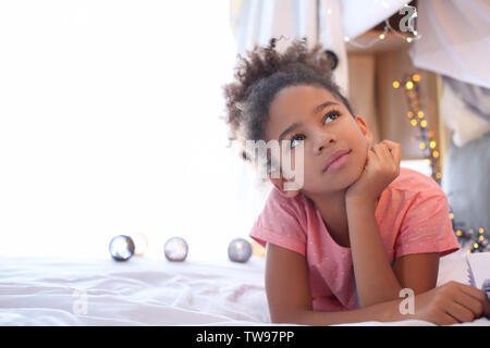Cute African American girl lying on bed Stock Photo - Alamy