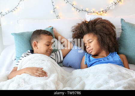 Cute African American children sleeping in bed. Family bedtime Stock Photo