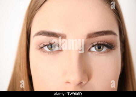 Young woman with eyelash loss problem on white background Stock Photo