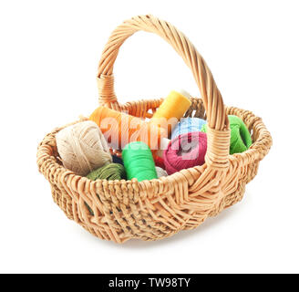 Wicker basket with colorful sewing threads on white background Stock Photo