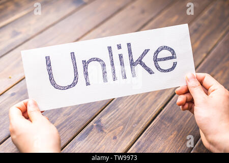 woman holds paper with word unlike in office Stock Photo - Alamy