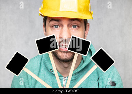 construction worker holding a blackboard with space for text or text, copy space, Stock Photo