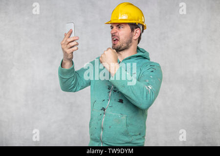 construction supervisor is shouting to a cell phone, copy space next to him Stock Photo