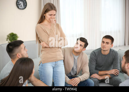 Young woman talking about her problems during group therapy Stock Photo