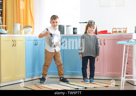 Cute little children playing with kitchenware at home Stock Photo