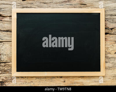 empty blank black chalkboard with wooden border frame on crack wooden background Stock Photo