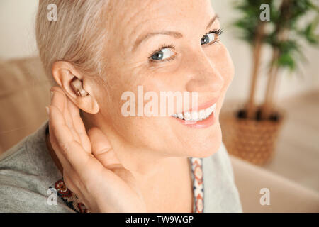 Mature woman with hearing aid, closeup Stock Photo