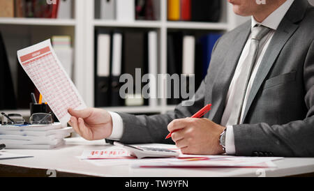 Businessman working and calculating, reads and writes reports. Office employee, table closeup. Business financial accounting concept. Stock Photo
