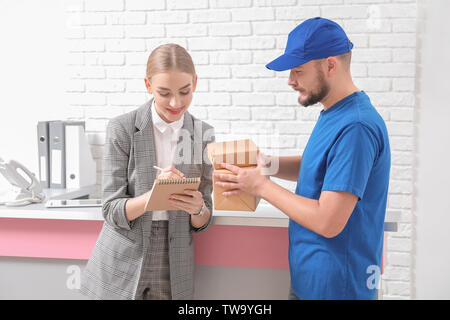 Female receptionist receiving parcels at workplace Stock Photo