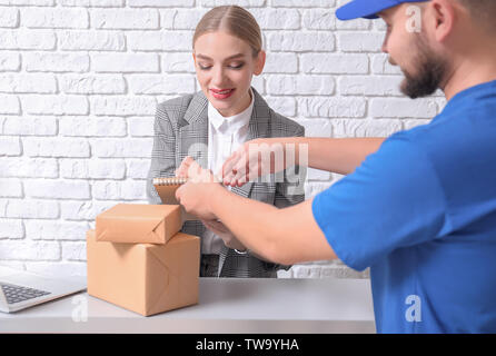 Female receptionist receiving parcels at workplace Stock Photo