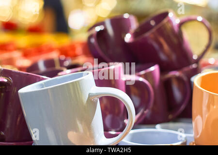 Many colorful empty ceramic cups in the store, Mugs background Stock Photo