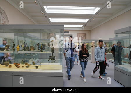 People look at the ancient Roman artefacts on display in Room 70 in the British Museum in London, United Kingdom. Stock Photo