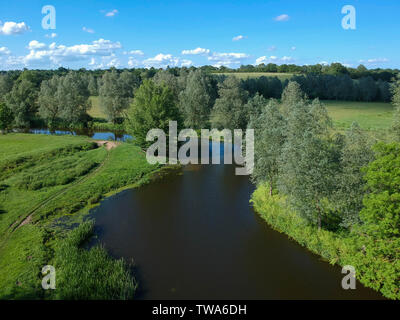 Arial view of a river winding through English countryside. Green fields and trees either side of the river and blue skies Stock Photo