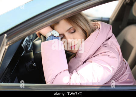 Tired woman sleeping inside car in traffic jam Stock Photo