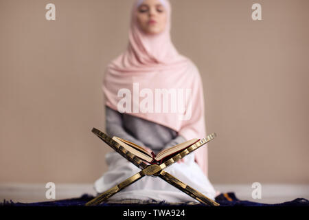 Young Muslim woman praying, indoors Stock Photo