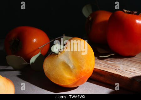 Tasty ripe persimmons on table Stock Photo