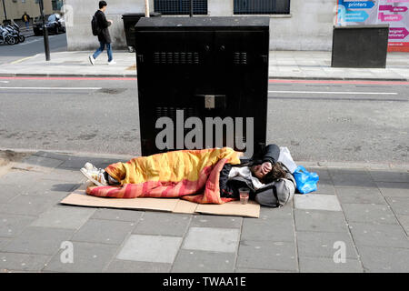 A homeless man sleeping on a pavement, Edgware Road, central London Stock Photo