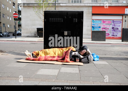 A homeless man sleeping on a pavement, Edgware Road, central London Stock Photo