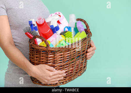 Woman holding basket with cleaning supplies Stock Photo by