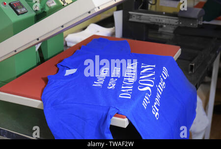 Modern printing machine with t-shirt at workplace Stock Photo