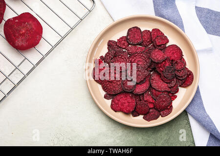 Plate with tasty beet chips on table Stock Photo