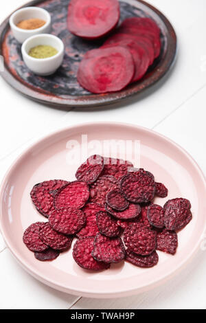 Plate with tasty beet chips on table Stock Photo