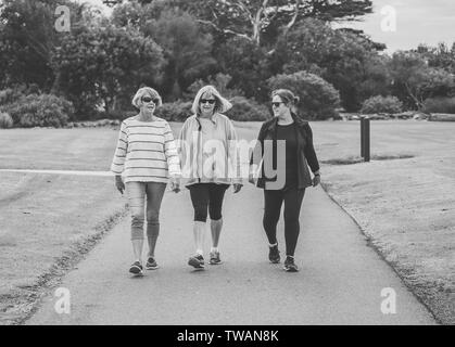 Lovely group of three senior mature retired women on their 60s walking in sportswear doing daily exercise routine together in People female friendship Stock Photo