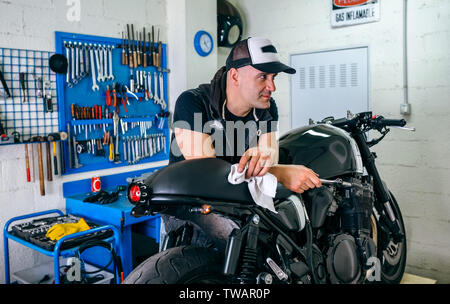 Mechanic posing with a motorcycle Stock Photo