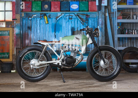 A motorbike on a stand in a garage workshop setting Stock Photo