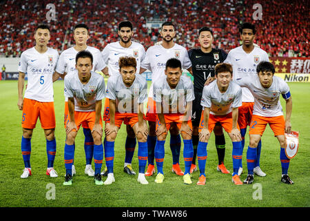 Players of the starting line-up of China's Shandong Luneng Taishan F.C. pose for photos before competing against China's Guangzhou Evergrande Taobao F.C. in the eighth-final match during the 2019 AFC Champions League in Guangzhou city, south China's Guangdong province, 18 June 2019. Thanks to Yang Liyu's lucky winner, Guangzhou Evergrande beat Shandong Luneng 2-1 in the first leg of AFC Champions League knock-out Round 1 here on Tuesday. Stock Photo