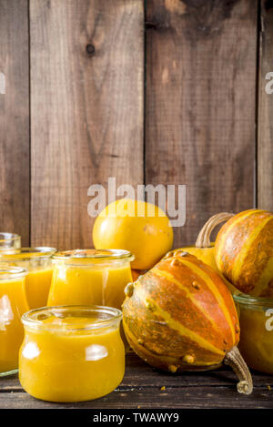 Autumn winter food. Pumpkin puree in different glass jars,with spices, Wooden background copy space Stock Photo