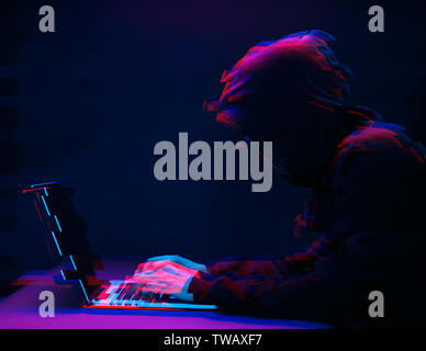 Hacker in the hood working with laptop typing text in dark room. Image with glitch effect Stock Photo