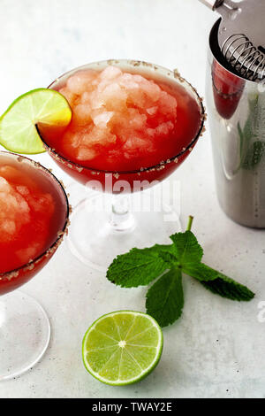 Red Frozen Margarita, refreshing cocktail on the table and lime with mint Stock Photo