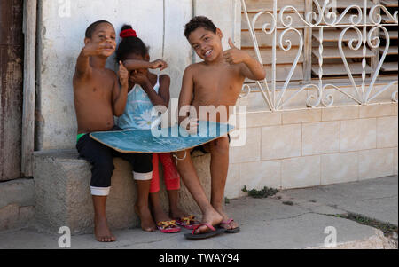 Cuban children playing Noughts and Crosses giving the V sign and thumbs in Trinidad, Cuba. Stock Photo