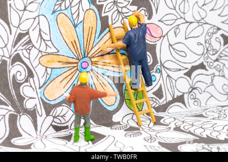 Macro shot on miniature figures as painters working on colouring details on a wallpaper Stock Photo
