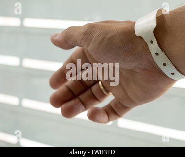Male hand with newborn hospital birth identification wrist tag. New father after baby birth.  New born name tag. Parents hospital ID wristband. Stock Photo
