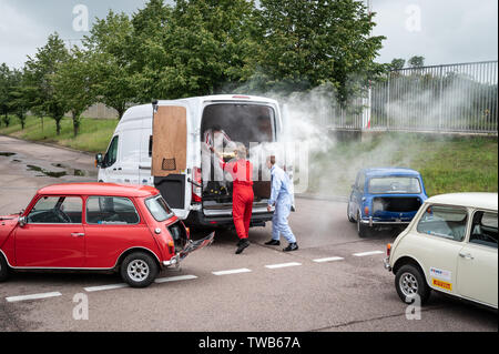 Mini plant, Oxford, UK. 19th June, 2019. Tribute to the Italian Job with a driving display and recreation of blowing the doors off the van to celebrate 60 years of Mini and 50 years since the release of the Italian Job film. The event was attended by Michael Deeley the  Oscar winning producer of the original film and David Salamone, a stunt driver who played Dominic in the original film in the red mini. Paul Swift (in white) led the driving stunts. Andrew Walmsley/Alamy Live News Stock Photo