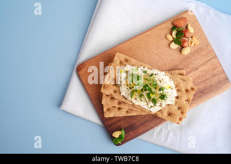 Crispbread with Cream Cheese and fresh herbs on a wooden Board, Healthy breakfast. Healthy breakfast Stock Photo