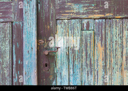 Old turquoise blue painted weathered wood wooden door detail texture with door handle Stock Photo
