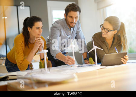 Attractive wind farm engineers looking over turbine placements Stock Photo