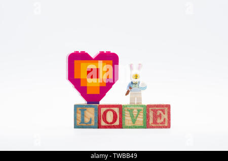lego bunny suit guy with easter egg and piece offering heart shape.  Lego minifigures are manufactured by The Lego. Stock Photo